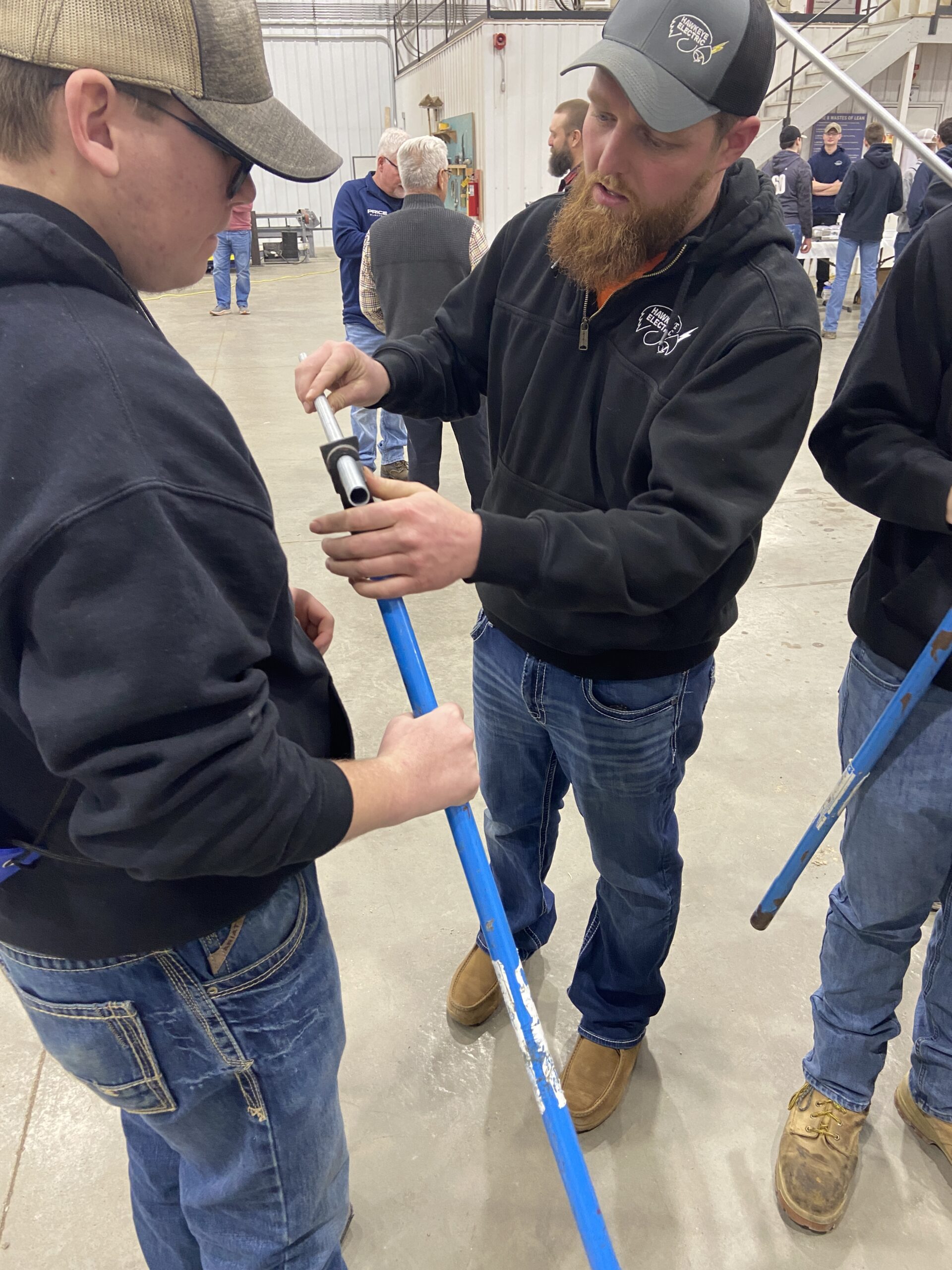 Student learns to bend conduit with electrician.